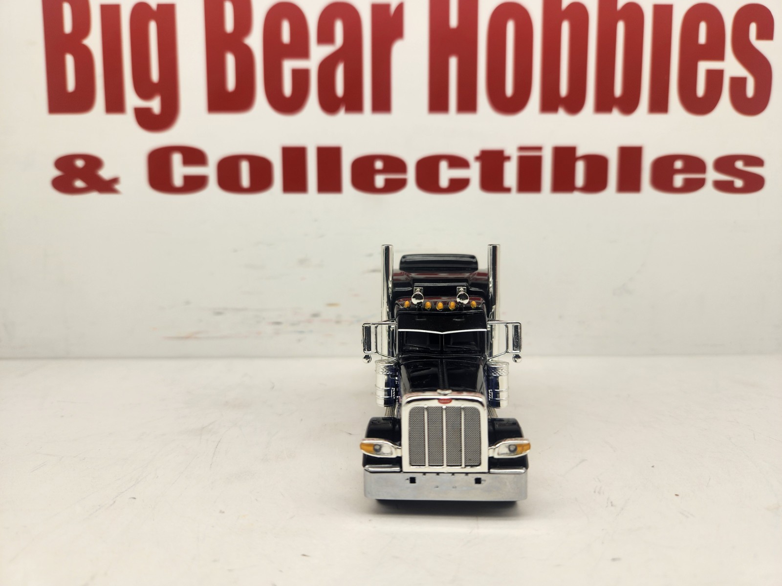 DCP 1/64 Black & Blue Graphics Peterbilt 389 63″ Midroof Sleeper Tractor