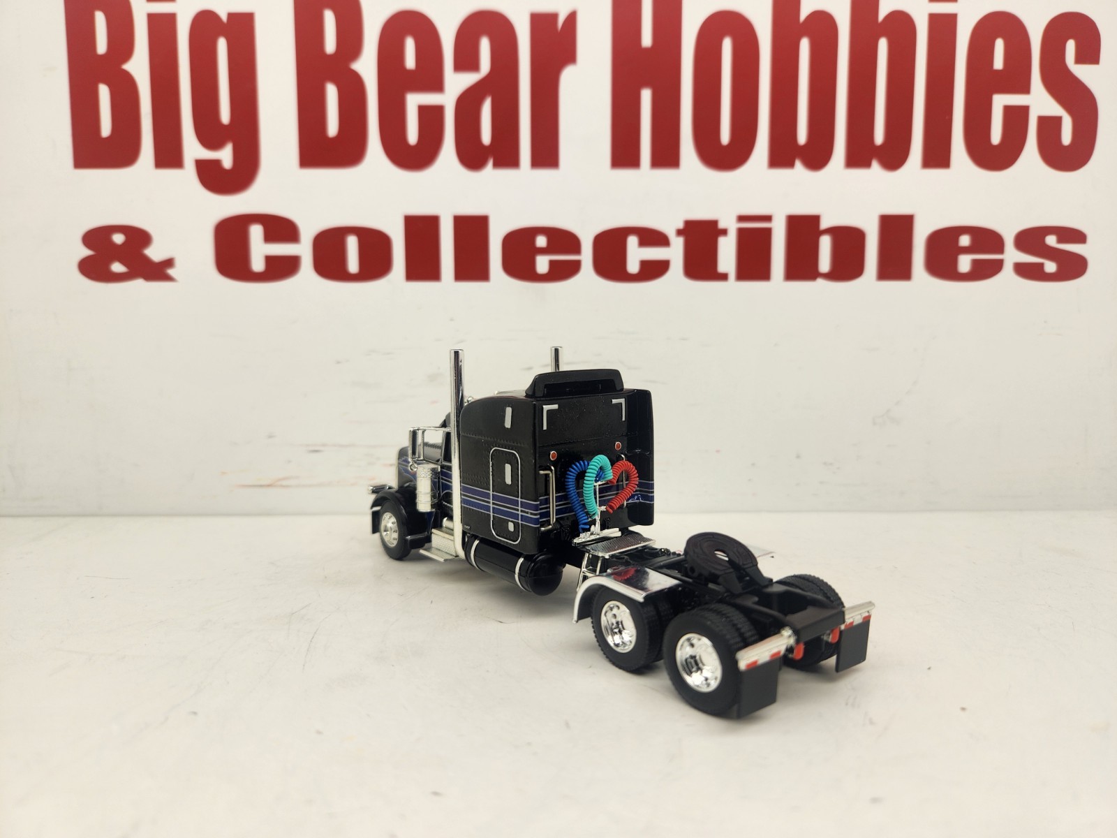 DCP 1/64 Black & Blue Graphics Peterbilt 389 63″ Midroof Sleeper Tractor