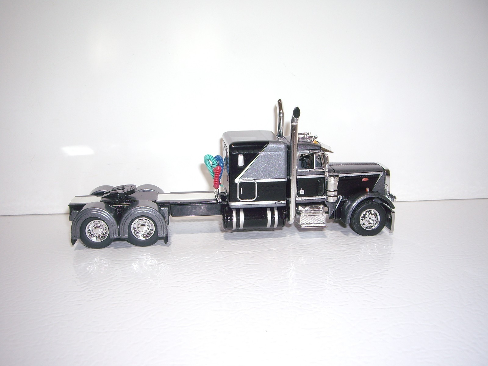 DCP FIRST GEAR 1/64 BLACK AND SILVER PETERBILT 379 WITH 63″ SLEEPER