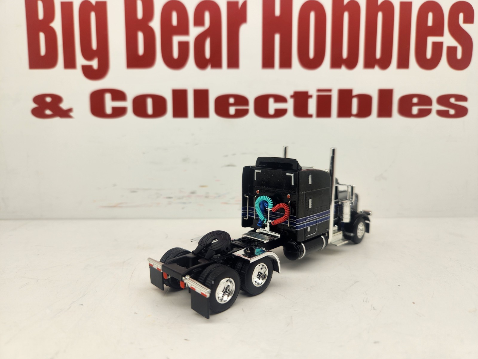 DCP 1/64 Black & Blue Graphics Peterbilt 389 63″ Midroof Sleeper Tractor