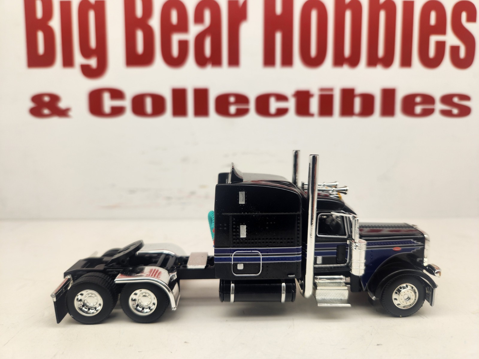 DCP 1/64 Black & Blue Graphics Peterbilt 389 63″ Midroof Sleeper Tractor