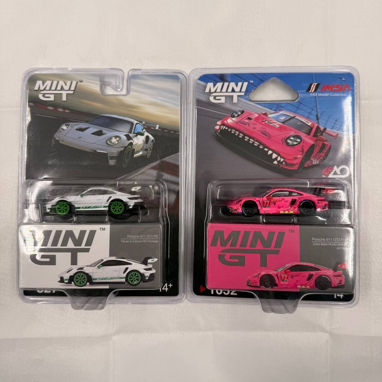Two MINI GT Porsche 911 GT3 R White Carbon Package AO Racing Rexy Pink 1/64