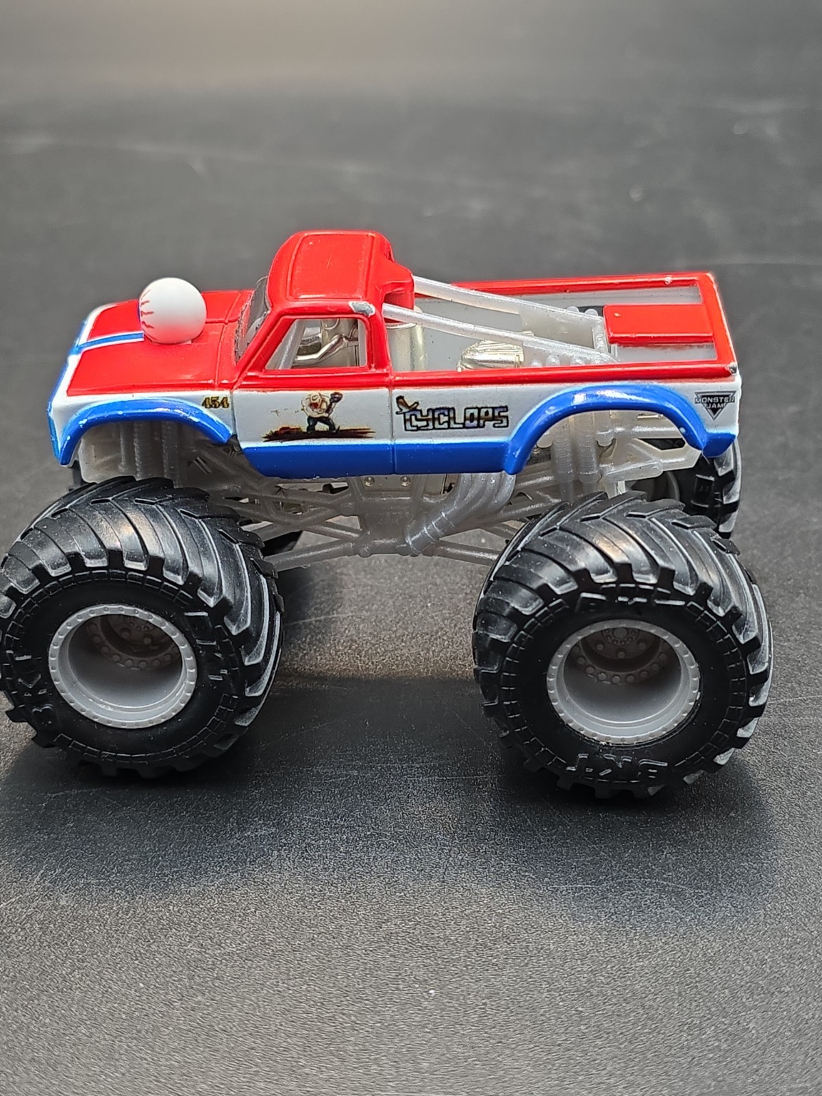 SPIN MASTER MONSTER JAM COLOR CHANGERS, CYCLOPS,RED/WHITE BLUE, 1:64