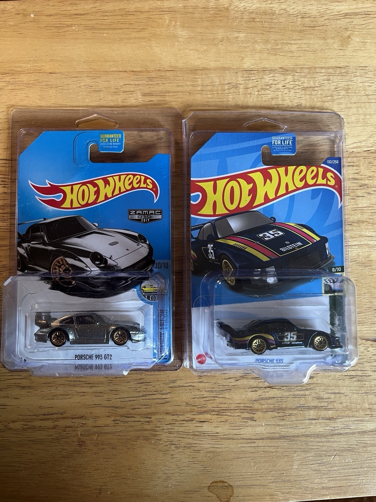 Hot Wheels – 2 – Porsches 993 GT2, ZAMAC Silver & 935 Blue In Plastic Protectors